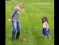 Student outside playing soccer with child