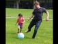 Student outside playing soccer with child