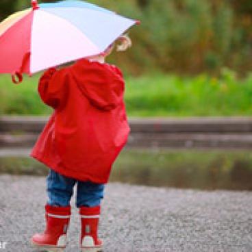 Little girl holding an umbrella up