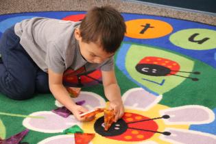 Toddler playing with a toy on a play mat